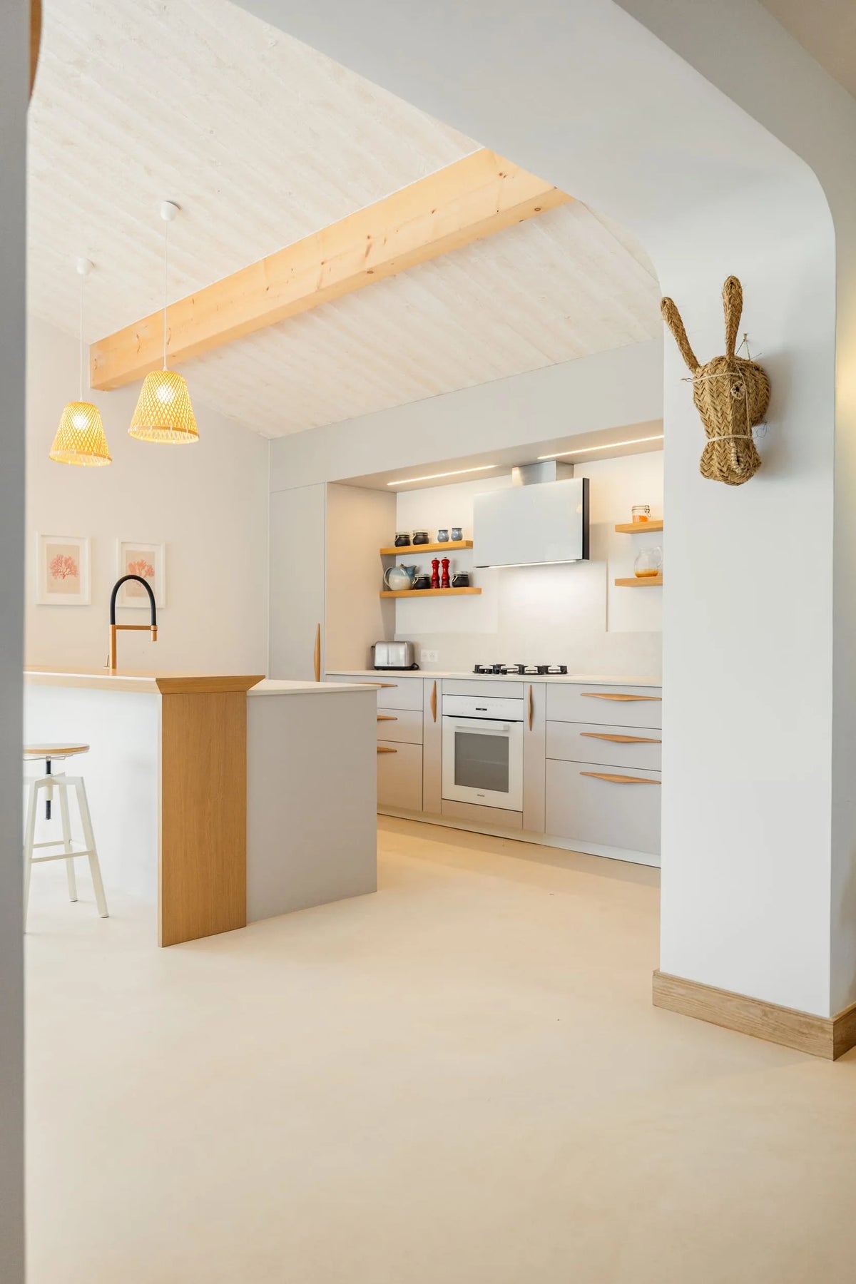 Cuisine à Ronce-les-Bains vue depuis une arche, plan Dekton Nebbia et façades claires